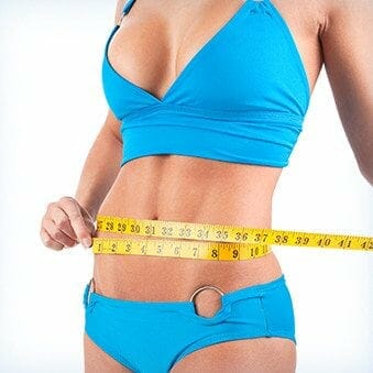 woman-in-blue-bikini-measuring-her-waist-post-tummy-tuck-procedure-sideimage